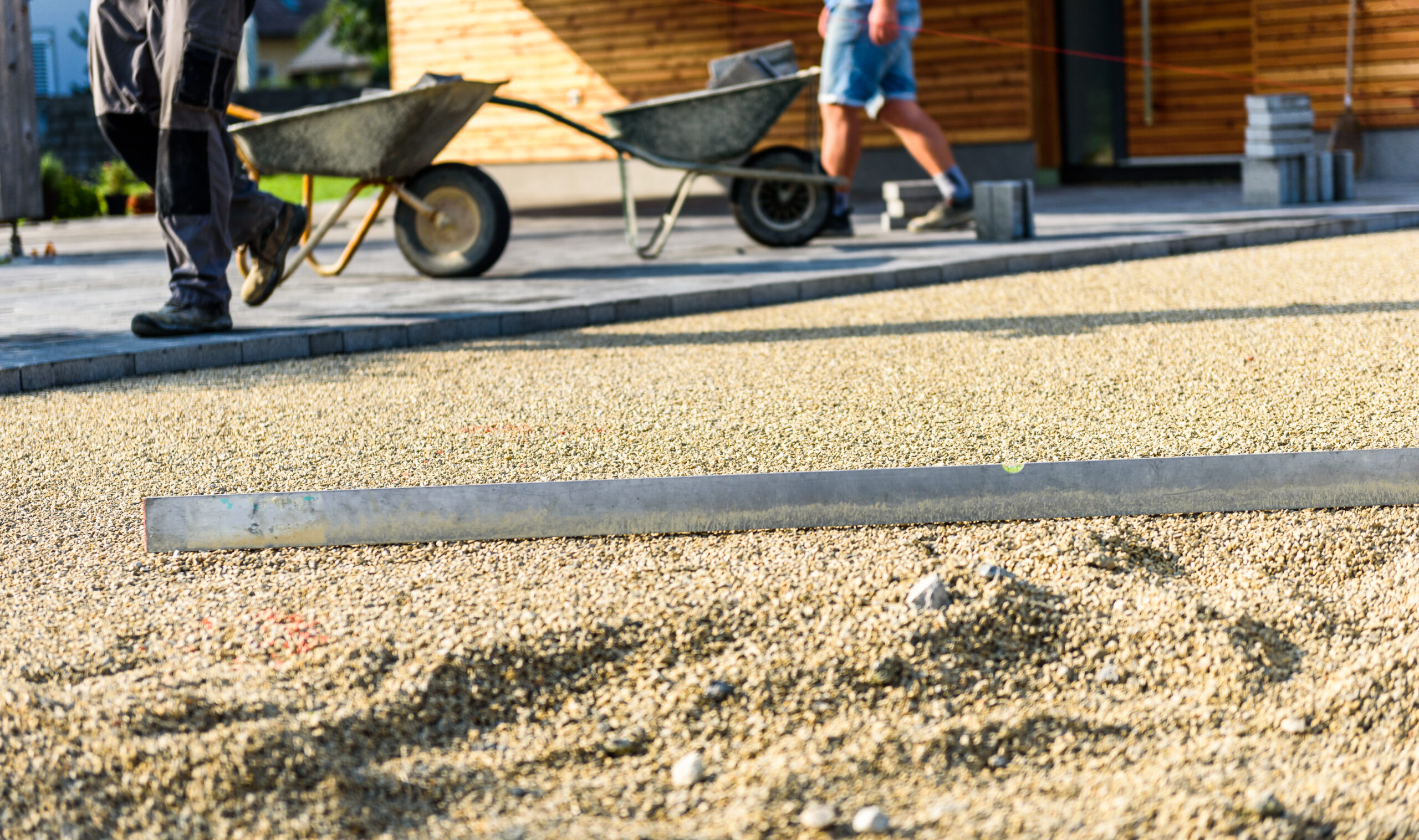 Low view of leveling bar on gravel base at job site.